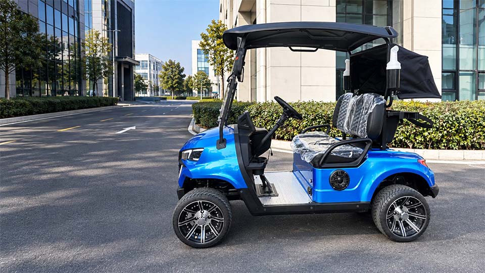 Blue two-seat golf cart with a black roof on a paved road