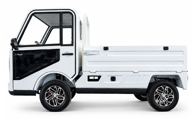 White electric pickup with an open driver door and a cargo bed