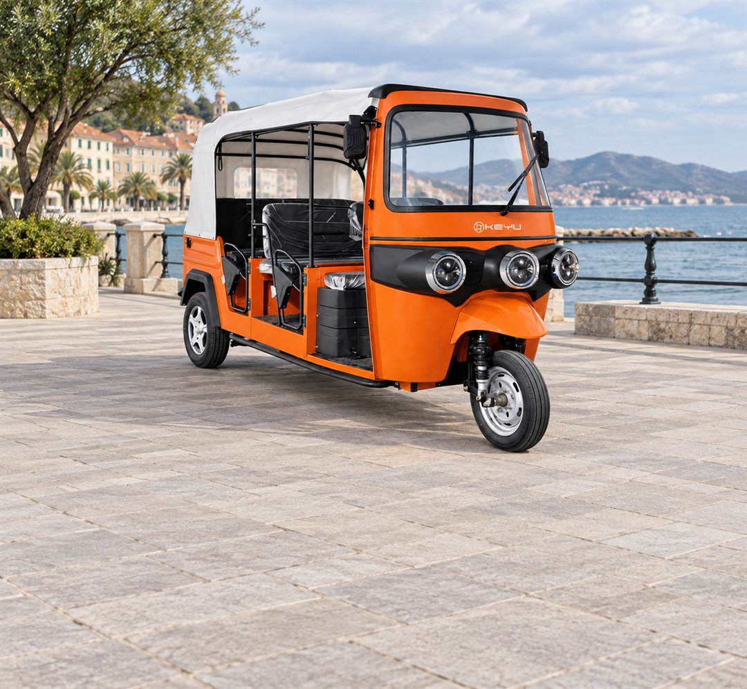 Orange passenger tuk tuk on a waterfront path